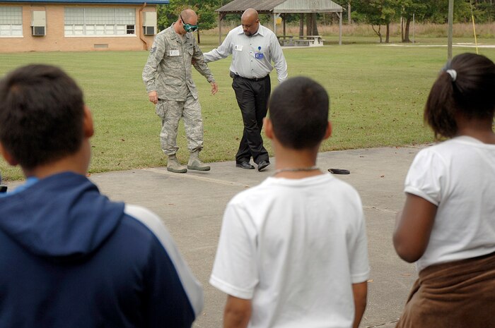 Students and faculty at Lambs Elementary watch as U.S. Air Force Staff Sgt. Bill Roeck and Mr. Selwyn Stephens demonstrate how an individual will walk if they've had too much to drink during a demonstration held at the school Oct. 26, 2010. Members of Joint Base Charleston visited local elementary schools during a week-long campaign to raise public awareness and mobilize communities to combat tobacco, alcohol and drug use. Sergeant Roeck is a military working dog handler with the 628th Security Forces Squadron and Mr. Stephens is with the 628th Medical Group as the drug demand reduction program manager. (U.S. Air Force photo/Staff Sgt. Marie Brown)