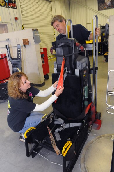 Lisa Harvey and Darrell Waters look over one of the seats refurbished by the F-15 Egress Shop. U. S. Air Force photo by Sue Sapp