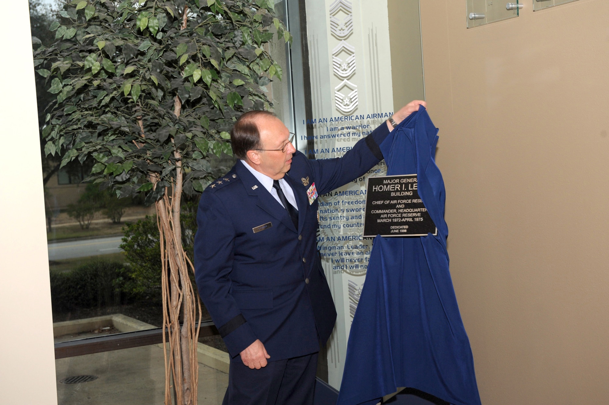 Lt. Gen. Charles E. Stenner, Jr., commander of Air Force Reserve Command, unveils the plaque bearing the name of retired Maj. Gen. Homer I. Lewis during a building re-dedication ceremony Oct. 25 at Air Force Reserve Command headquarters, Robins Air Force Base, Ga.  General Stenner re-dedicated the main headquarters building to General Lewis; the headquarters annex to retired Chief Master Sgt. Robert I. Boyle; and the Professional Development Center to Lee C. Lingelbach.  (U.S. Air Force photo/Raymond Crayton, Jr.) 
