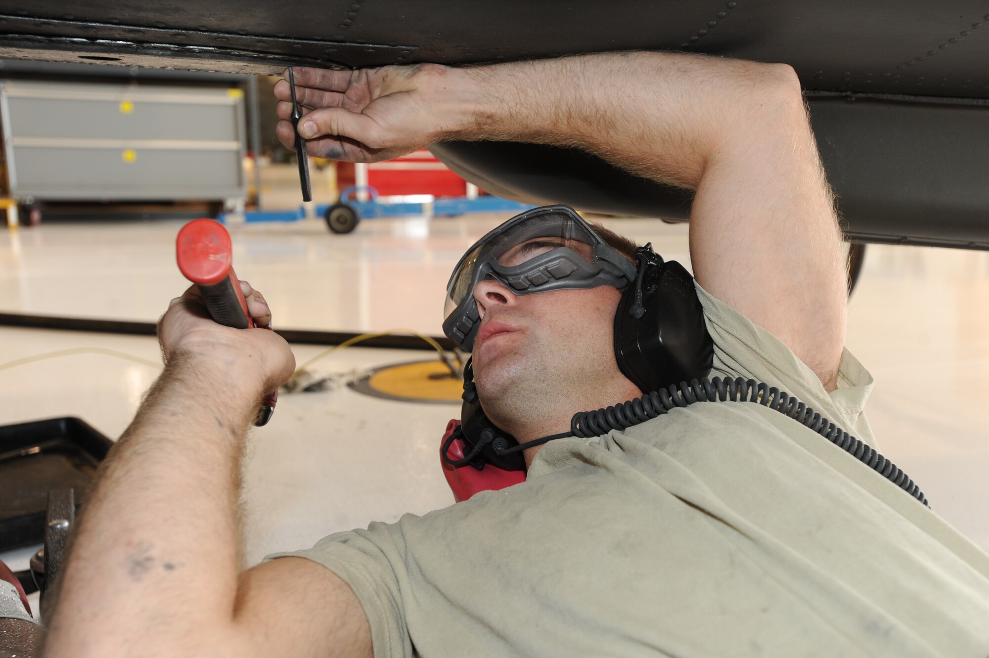 WHITEMAN AIR FORCE BASE, Mo. - Army Private 1st Class Randall Mayo, 1-135th Attack Reconnaissance Battalion maintenance technician, repairs rivets on the fuselage of an AH -64 Attack Apache, Oct. 26. Whiteman Air Force Base is home to the Army Aviation Support facility which maintains the Apache Helicopter while the 1-135th ARB is not here. (U.S. Air Force photo by Senior Airman Carlin Leslie)


