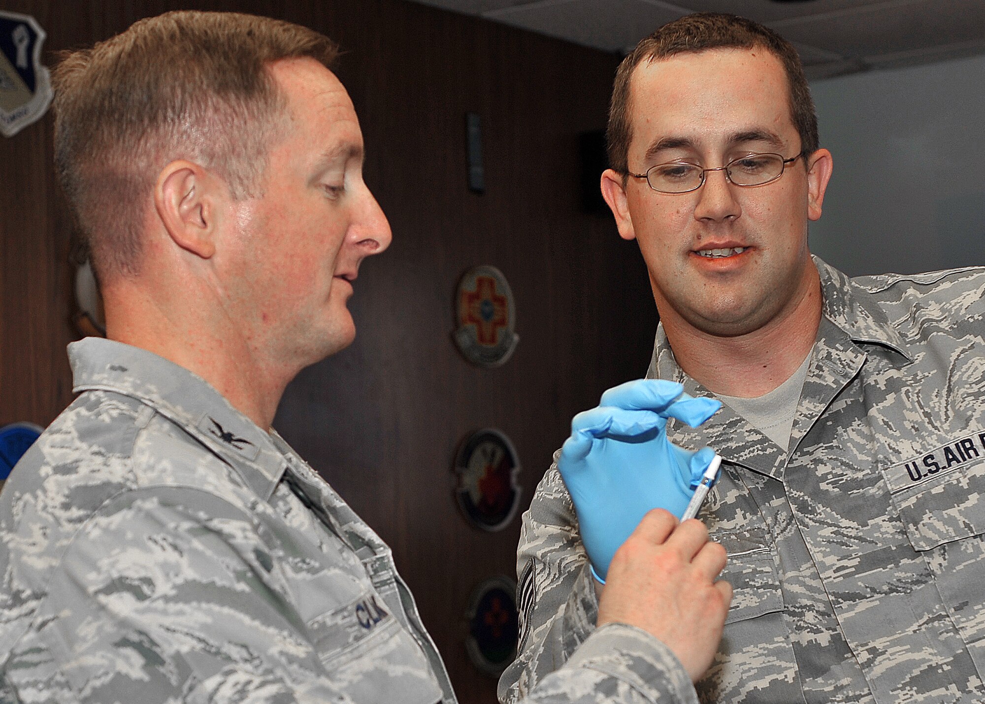 Staff Sergeant Daniel Leigh, 27th Special Operations Medical Operation Squadron, explains the flu shot process to Colonel Stephen Clark, 27th Special Operations Wing commander, at the wing staff meeting, Oct. 26. September through March is considered flu season and active duty service members can walk in to the base immunizations office and receive the flu mist. Active-duty family members at Cannon Air Force Base, N.M., who are at high risk can call 784-4040 to make an appointment. To find out if you're high-risk, go to www.cdc.gov. (U.S. Air Force photo by Senior Airman James Bell)