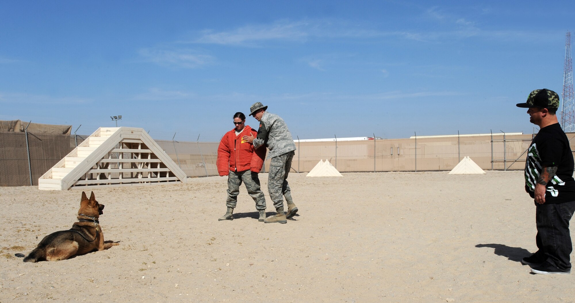 SOUTHWEST ASIA -- Actor Jason Acuña (right), who plays the role of Wee-Man in the movie "Jackass 3D," watches as Staff Sgt. Brandon Rimmer of 386th Expeditionary Security Forces Squadron performs a canine demonstration at an undisclosed air base Oct. 25, 2010. Acuña was here to visit with troops and sign autographs as part of a promotional tour for the new movie. (U.S. Air Force photo by Senior Airman Laura Turner)