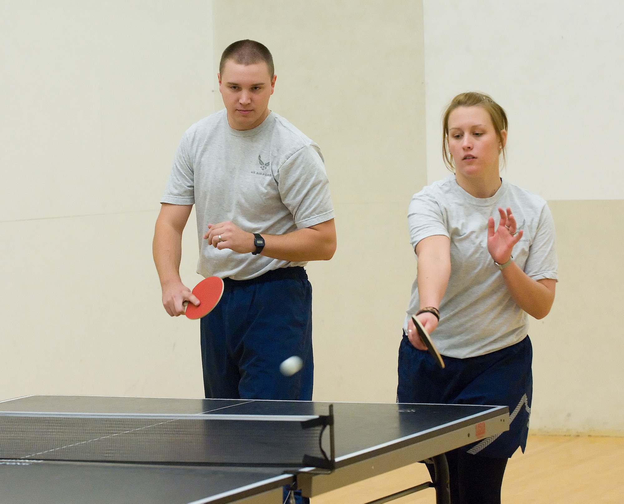 (Left) Airman 1st Class Aaron Berkebile, 436th Communications Squadron, and Airman Chelsea Weller, 436th CS, play in the ping pong tournament during Fall Wing Sports Day at the Fitness Center, Dover Air Force Base, Del., Oct. 22, 2010. Fall Wing Sports Day featured many different kinds of sports such as volleyball, softball and golf. (U.S. Air Force photo by Jason Minto/Released)