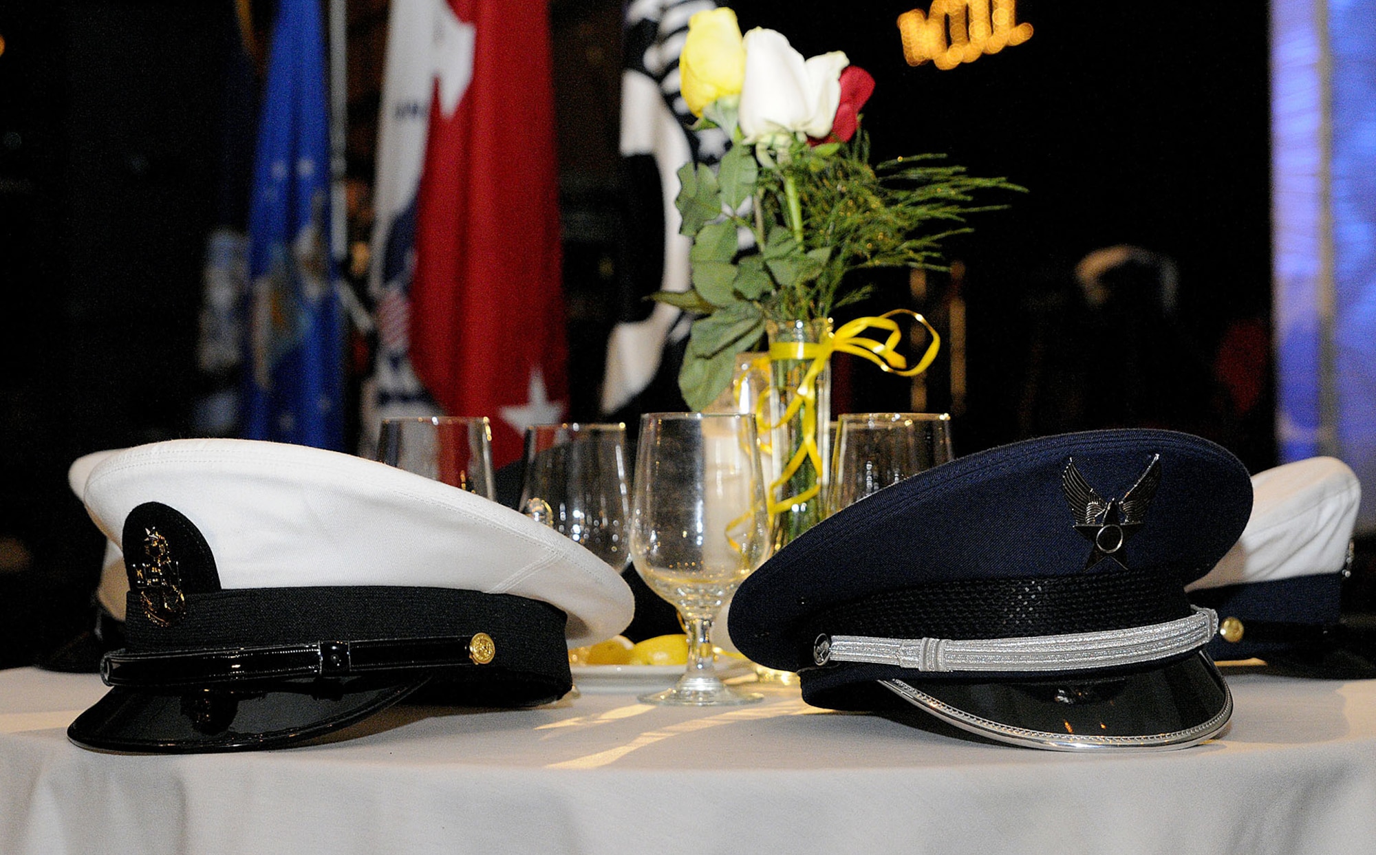 CHARLESTON, SC (October 23, 2010) United States Navy, Air Force, Army, Marine Corps, and Coast Guard service hats rest on a Prisoner of War/Missing in Action table during a presentation during the Joint Base Charleston Military Ball held at the North Charleston Convention Center, Oct. 23, 2010. The setting of the POW/MIA table is a time-honored ceremony in recognition of captured, killed in action and missing comrades from each service. (U.S. Navy photo/Mass Communication Specialist 1st Class Jennifer R. Hudson)