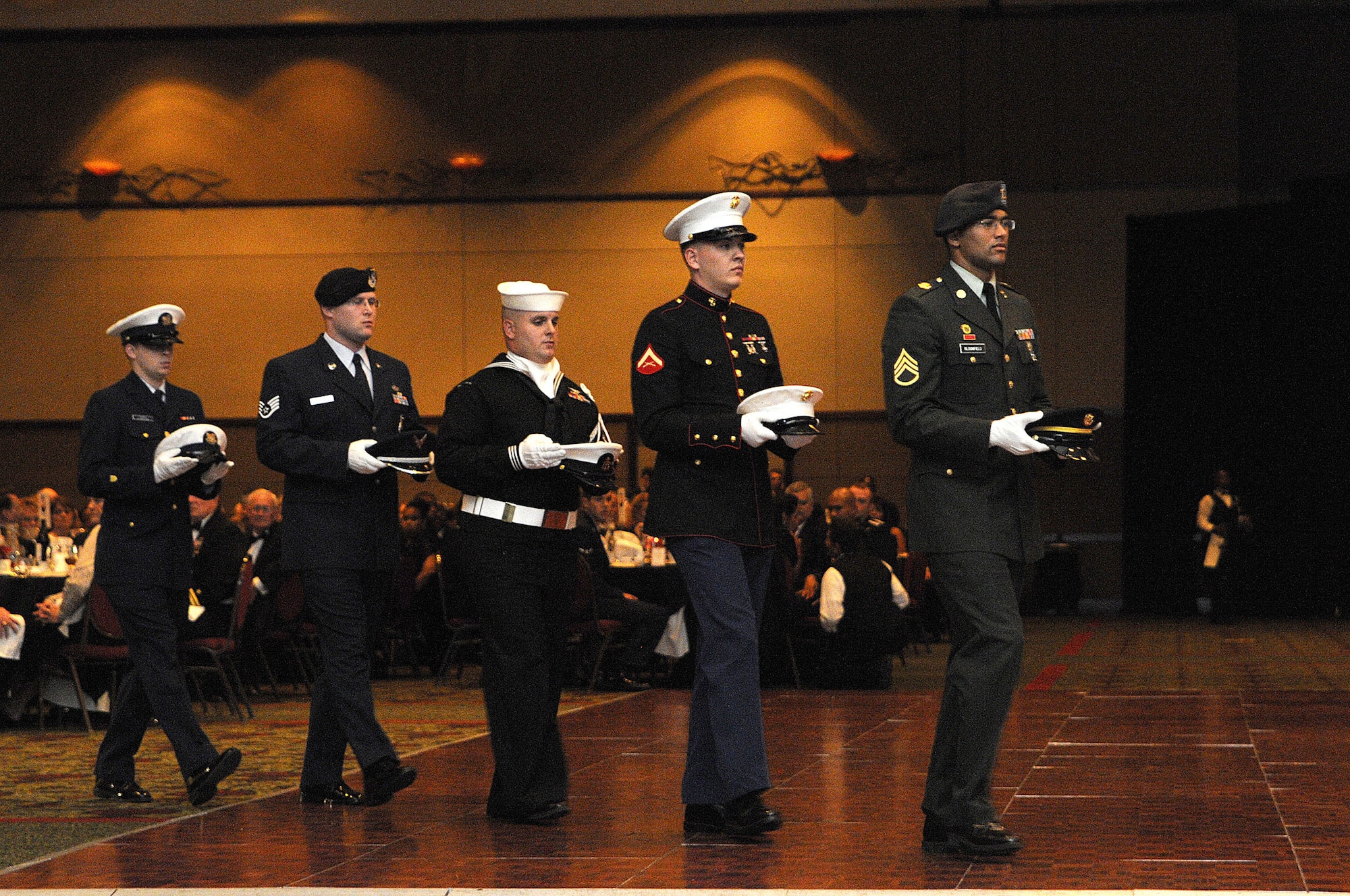 CHARLESTON, SC (October 23, 2010) United States Army, Marine Corps, Navy, Air Force and Coast Guard service members carry their respective service hats as part of a Prisoner of War/Missing in Action recognition presentation during the Joint Base Charleston Military Ball held at the North Charleston Convention Center, Oct. 23, 2010. The presentation honors captured, killed in action and missing comrades from each service. (U.S. Navy photo/Mass Communication Specialist 1st Class Jennifer R. Hudson)