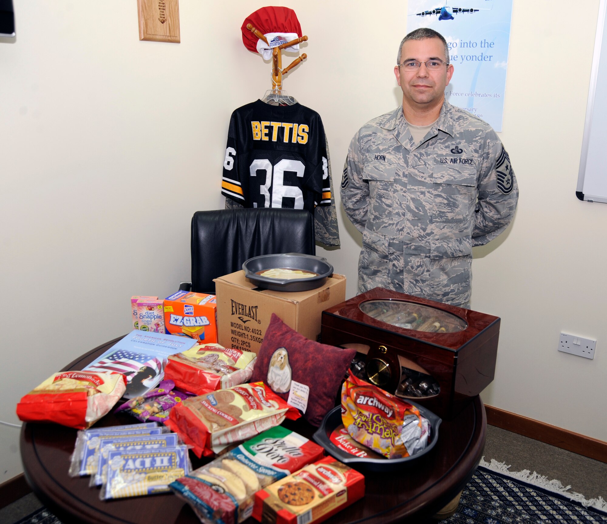 Chief Master Sergeant Timothy Horn, 380th Air Expeditionary Wing Command Chief Master Sergeant, poses with items from a large shipment of care packages that he was able to parcel out to Airmen across this undisclosed base in Southwest Asia and other Airmen across the area of responsibility. The packages were donated by Our Troops Online, a charitable organization founded by Bob Williams. (U.S. Air Force photo/Staff Sgt. Jeremy Larlee)