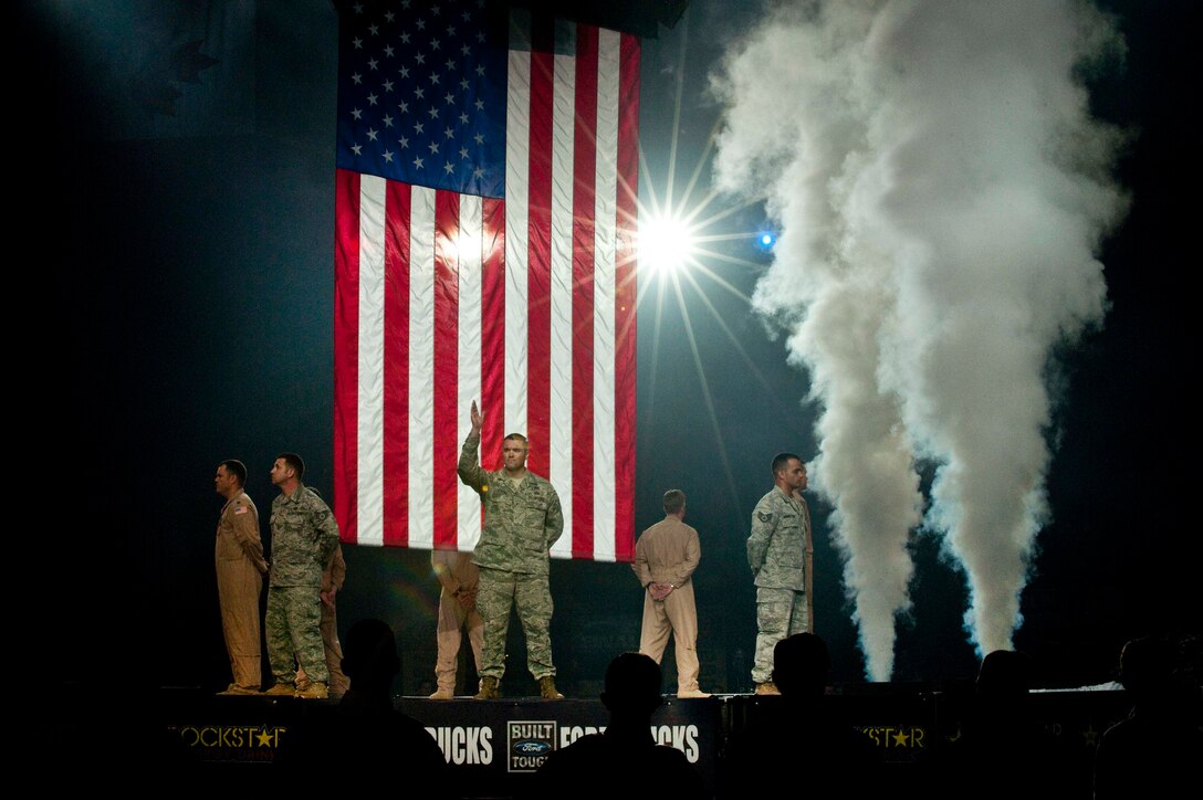 Airmen from Nellis Air Force Base, Nev., wave to the crowd during the opening ceremonies of the Professional Bull Riders World Finals at the Thomas & Mack Center in Las Vegas Oct. 22.  Nellis Air Force Base Airmen were honored for their service during Air Force night at the event.  (U.S. Air Force photo/Tech. Sgt. Michael R. Holzworth)