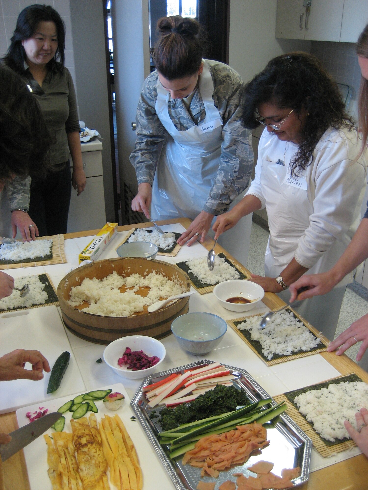YOKOTA AIR BASE, Japan -- 1st Lt. Jenna Mirandette the 374th Airlift Wing Sexual Assault Response Coordinator, and Maribel Edwards place Japanese rice that has been mixed with sushi vinegar on a sheet of nori as a base to their maki-zushi, or sushi roll.  This Japanese cooking class was offered by the 374th Force Support Squadron’s Airman and Family Readiness Center Oct. 27 as a way to introduce Yokota members to Japanese culture.  Classes are offered up to twice a month.  (U.S. Air Force photo/Capt. Tania Bryan)