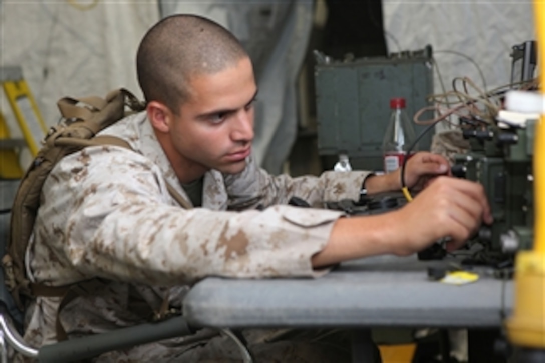 Cpl. David P. Ghantous, a radio operator for the 22nd Marine Expeditionary Unit, checks the functions of a radio during a command post exercise at Marine Corps Base Camp Lejeune, N.C., on Oct. 20, 2010.  The Marine Expeditionary Unit's command element practiced assembling the command post to ensure all necessary equipment functions properly and is not damaged for future exercises and deployments.  