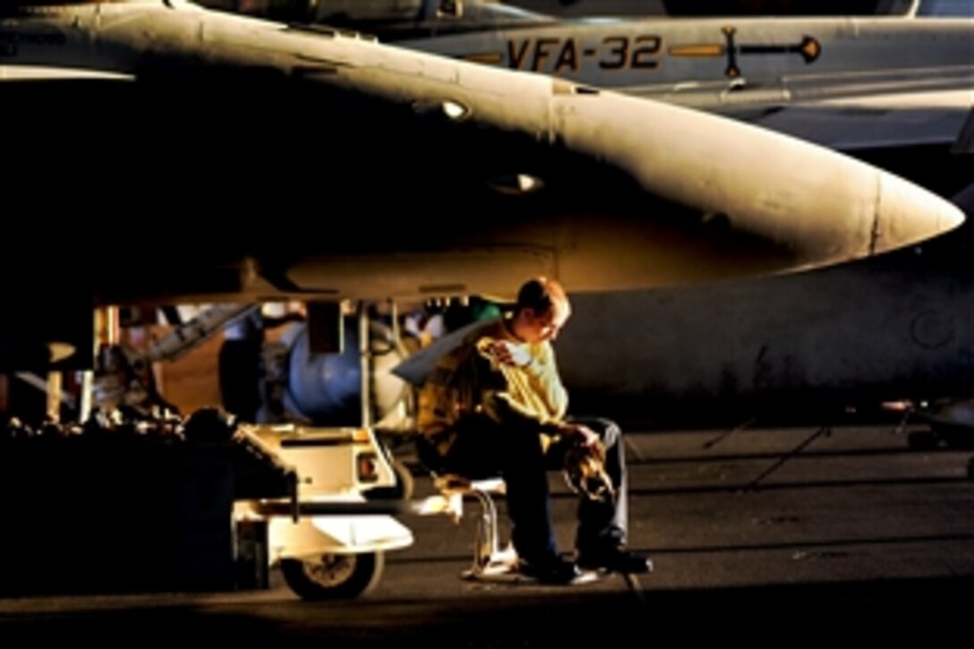 U.S. Navy Petty Officer 2nd Class Paul Seat takes a short break in the hangar bay aboard the USS Harry S. Truman in the Arabian Gulf, Oct. 25, 2010. Seat is an aviation boatswain's mate.