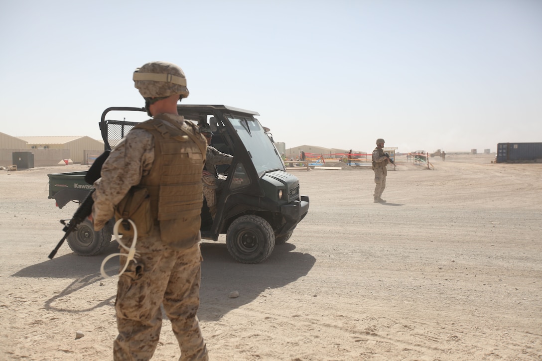 Cpls. Zachary Sedam, an operations clerk with 3rd Marine Aircraft Wing (Forward), and Michael Grabowsky, a Marine Corps Integrated Maintenance Management System specialist with Marine Wing Headquarters Squadron 3, 3rd MAW (Fwd), position themselves on opposite sides of the street at a key intersection to set up a snap vehicle check point aboard Camp Leatherneck, Afghanistan, during a simulated threat exercise Oct. 27.  Both Marines are members of the MWHS-3 Sector Response Team, which is comprised of Marine augments from tenant commands aboard the base that are responsible for the security of specific sectors of the base. SRTs are recalled in response to threats in security and emergencies.