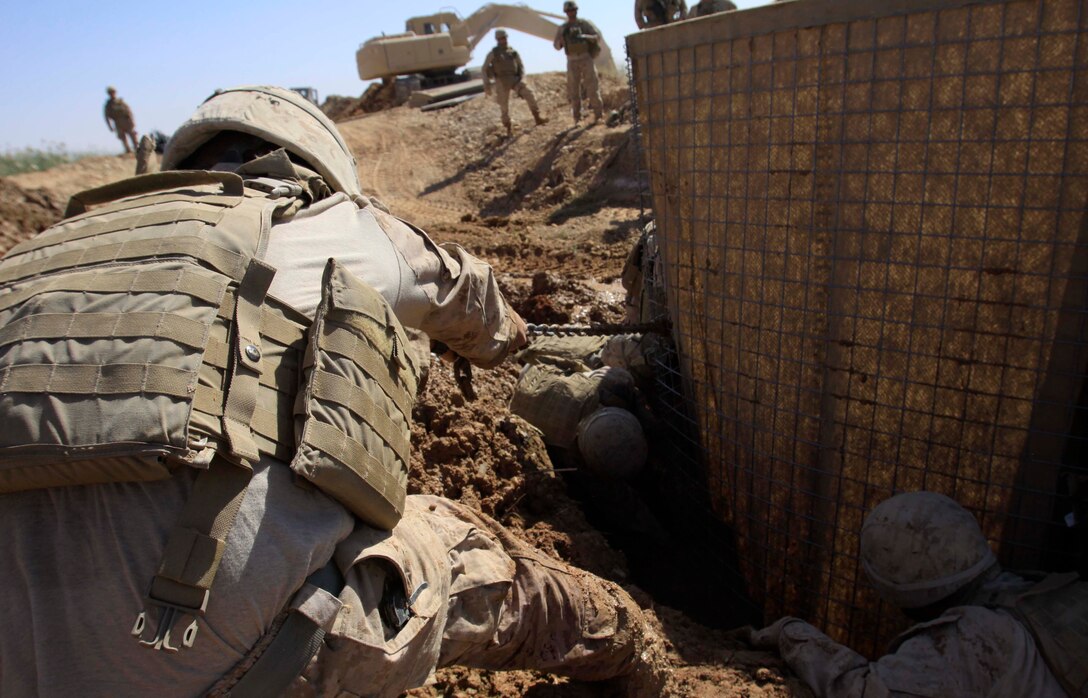Lance Cpl. William Crabbe, combat engineer, Engineer Co., Combat Logistics Battalion 3. 1st Marine Logistics Group (Forward), helps straighten a Hesco barrier in Trakh Nawa, Afghanistan, Oct. 27. Approximately 40 Marines with CLB-3 constructed a bridge to be used for military personnel and civilians in the area.