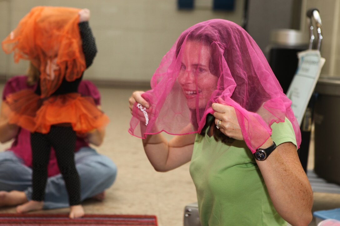 Melissa Russell, the Kindermusik instructor, dons a pink scarf over her head during a Kindermusik class at Tarawa Terrace Community Center in the Marine Corps Base Camp Lejeune housing area, Oct. 28.  Kindermusik is a music and movement program that teaches children a number of skills crucial to child development.