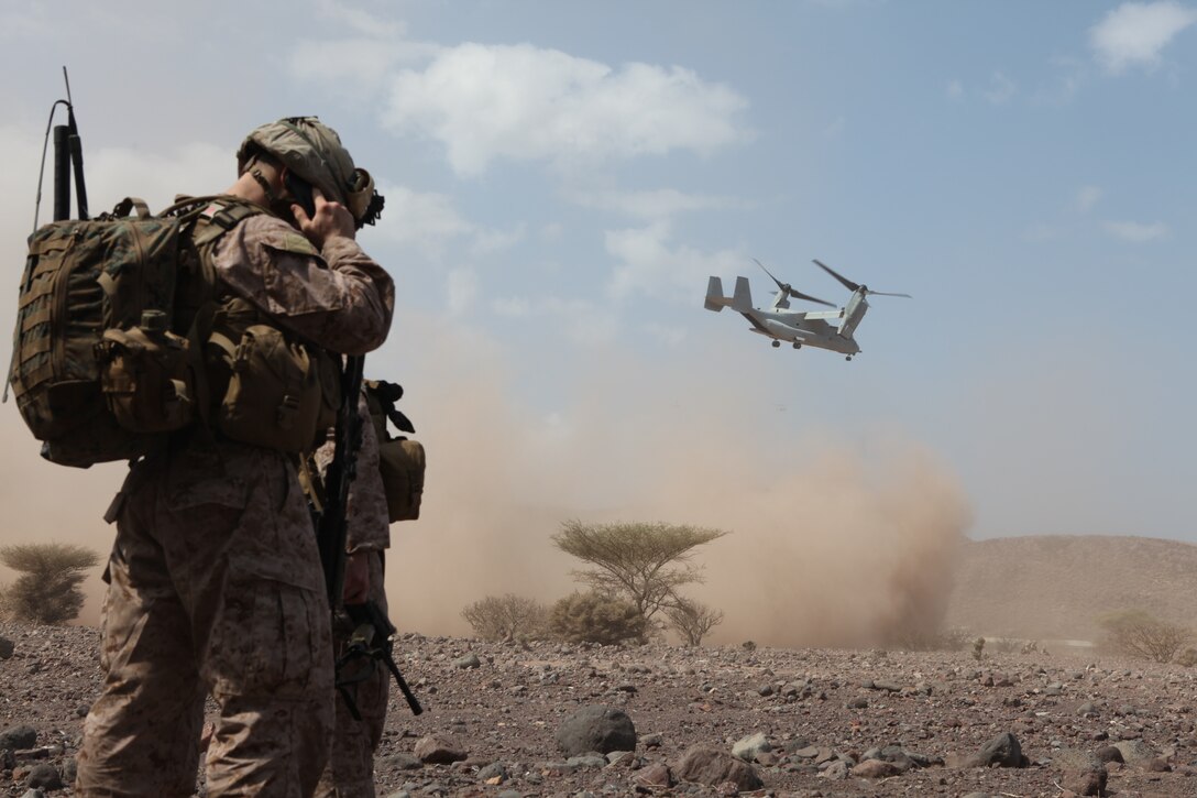 Corporal Conor Wood, a radio operator with Company I, Battalion Landing Team 3/8, 26th Marine Expeditionary Unit, communicates with his team while an MV-22 Ospreys takes off from the landing zone during a simulated vertical assault in Djibouti, Africa, Oct. 28, 2010. Elements of 26th MEU conducted sustainment training during their current deployment at Camp Lemonnier and surrounding areas.