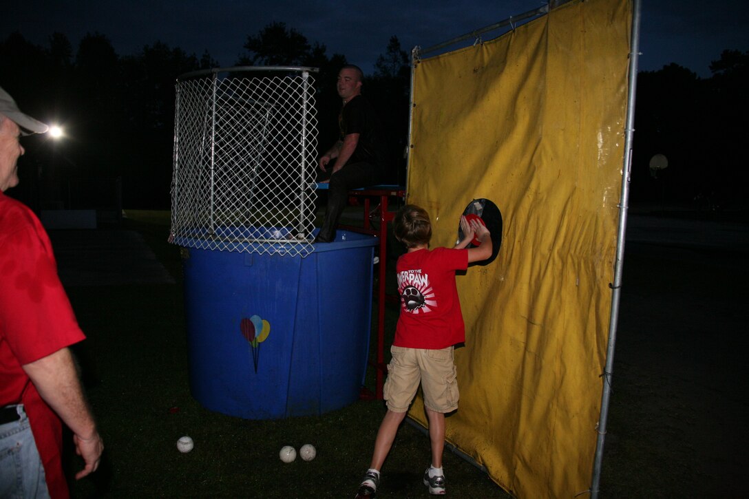 Lance Cpl. Thomas B. McCarthy prepares for a dip in the dunk tank as a student pushes the button during the Halloween Fair held at Bangert Elementary School, Oct. 28. The Single Marine Program has adopted Bangert and will be returning to the school to volunteer for a book reading day the end of November. “It was great seeing the kids’ faces as they pushed the button after they missed,” said McCarthy. “It was fun just being around the kids and helping out.”