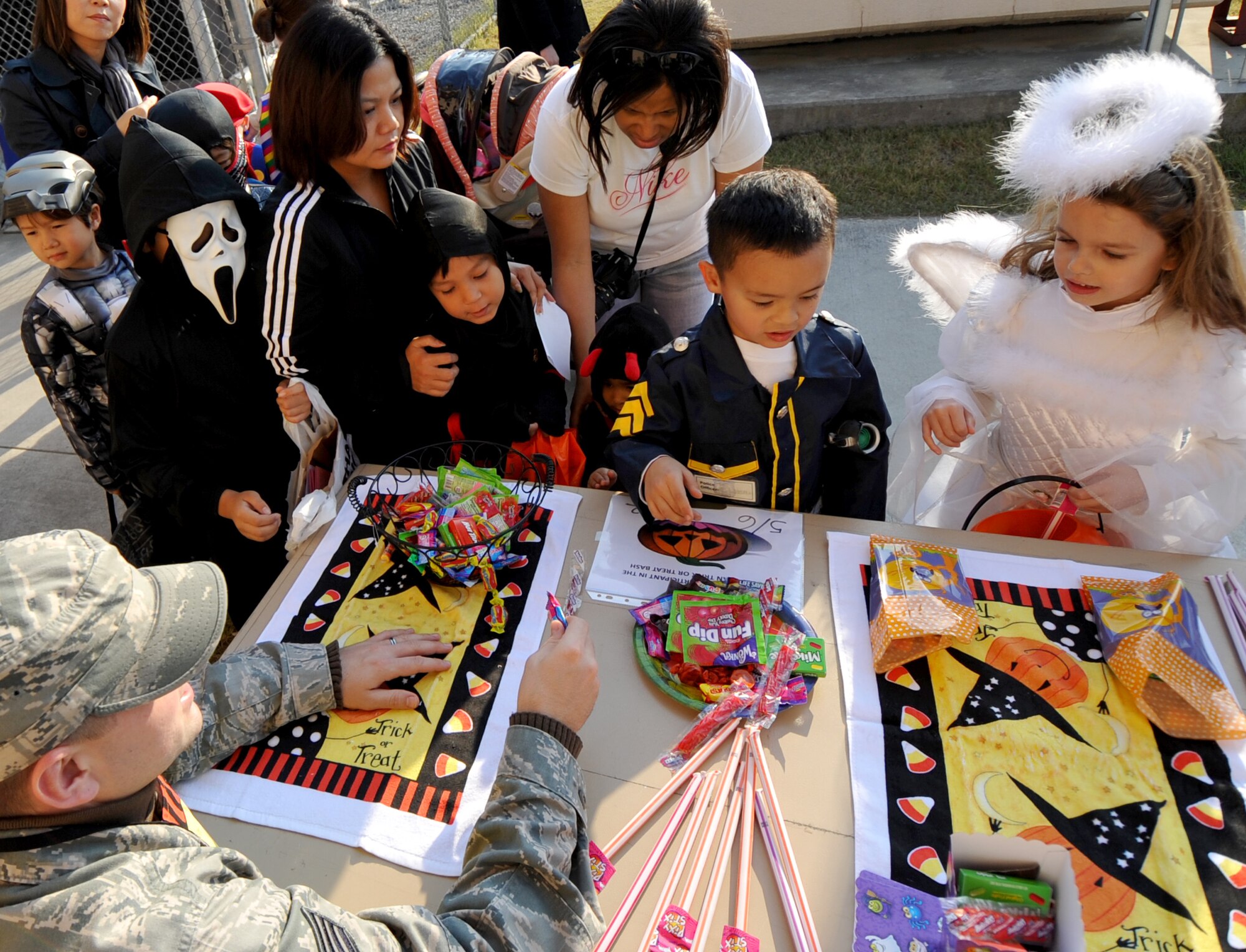 Children gather around candy booths at the second annual Osan Trick-or-Treat Bash Oct. 28. Candy was handed out through a safe maze of offices and booths from military personnel and base organizations. The Trick-or-Treat Bash was followed by a costume contest at the Officers club. (U.S. Air Force Photo/Senior Airman Evelyn Chavez)