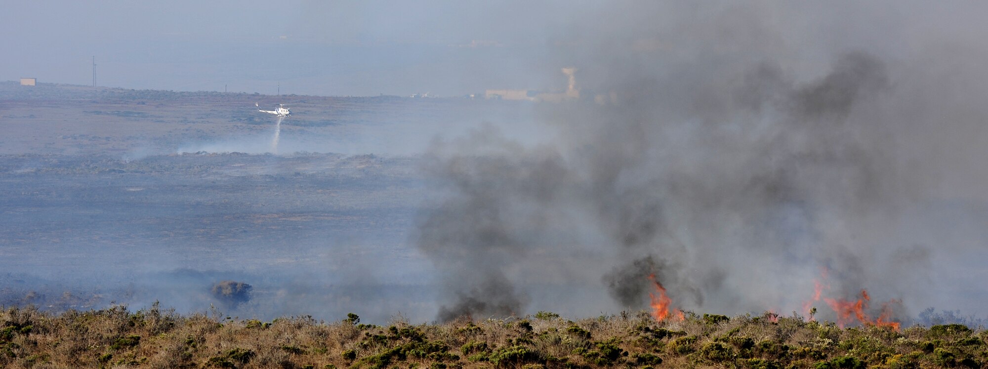 VANDENBERG AIR FORCE BASE, Calif. -- In an attempt to contain the Bear Creek Fire, a helicopter dumps water over the flames here Thursday, Oct. 28, 2010. Approximately 150 firefighters and emergency responders are working to contain the fire which broke out at 1 p.m. on south base near Space Launch Complex 3. (U.S. Air Force photo/ Senior Airman Ashley Reed)
