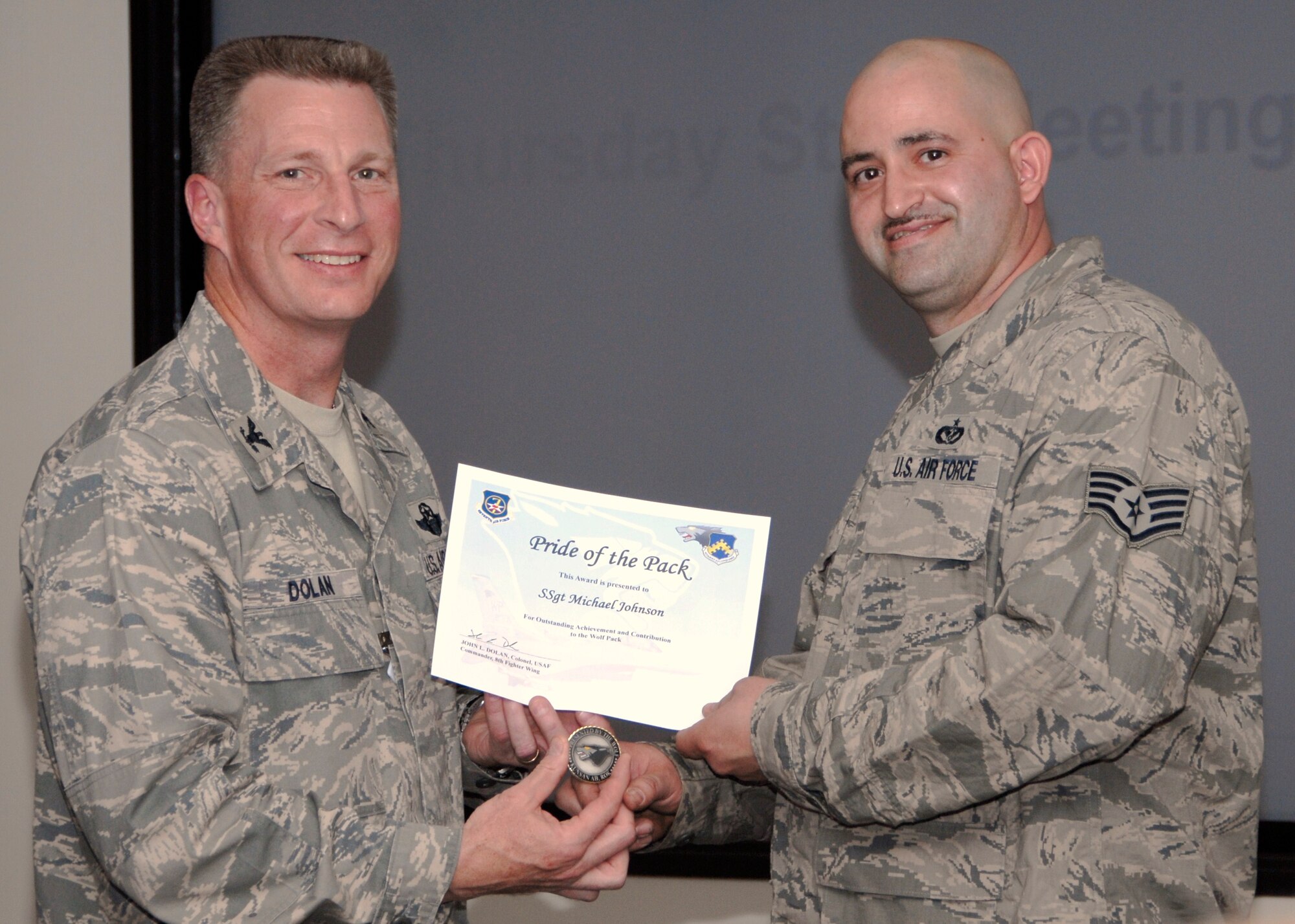 KUNSAN AIR BASE, Republic of Korea -- Col. John Dolan, 8th Fighter Wing commander, presents Staff Sgt. Michael Johnson, 8th Civil Engineer Squadron, with a Pride of the Pack award Oct. 28. (U.S. Air Force photo/Capt. Sheryll Klinkel)