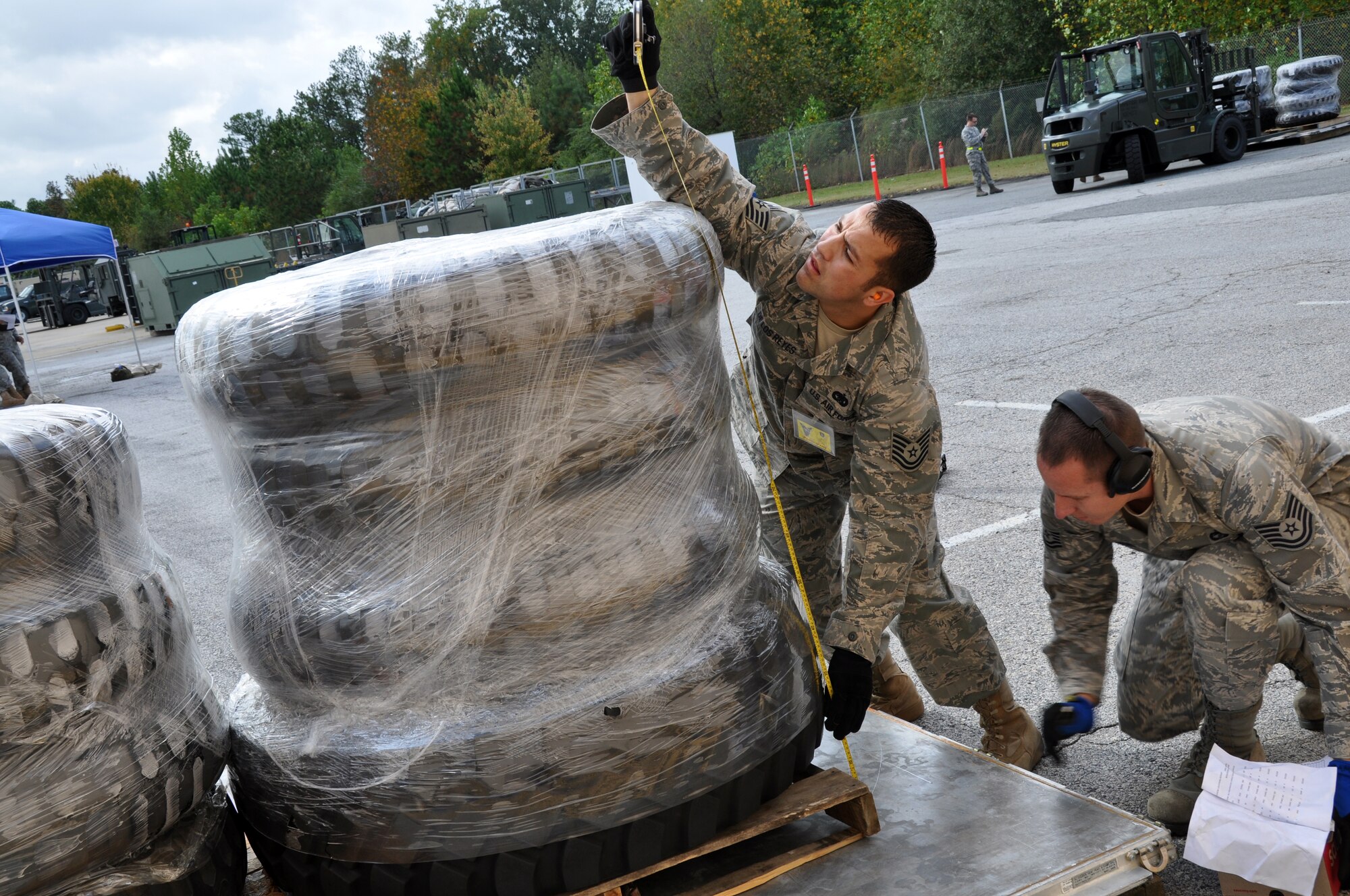 Tech. Sgt. Cody De Los Reyes and Tech. Sgt. Justin Adams, 67th Aerial Port Squadron, measure the height of a pallet stocked with tires during the pallet-building event at AFRC's Port Dawg Challenge Oct. 26. (U.S. Air Force photo/Bryan Magaña)