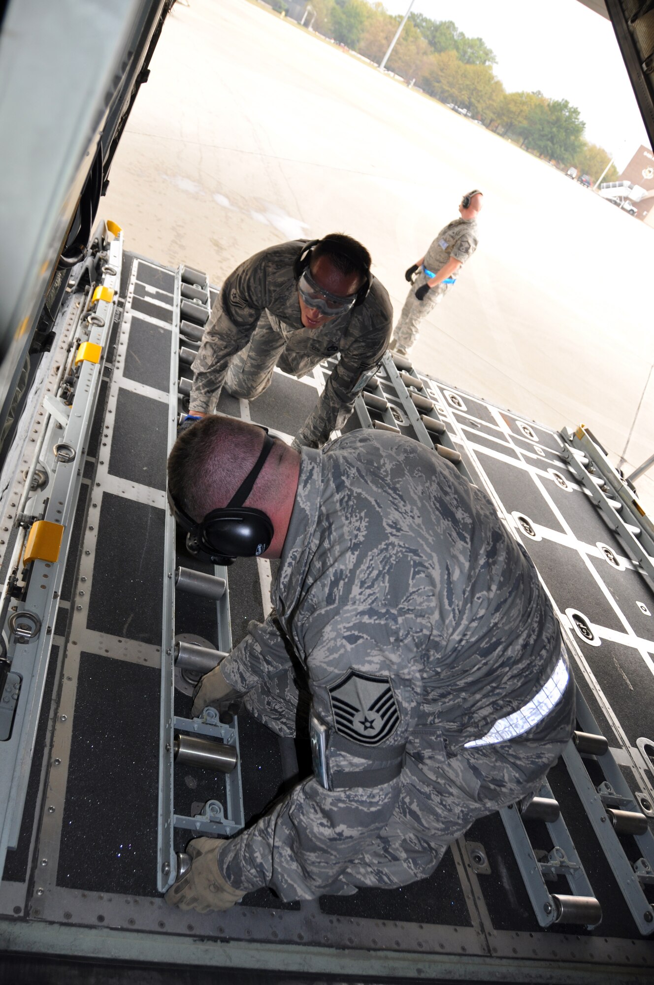 Master Sgt. Keith Quimby (front) and Tech. Sgt. Justin Adams, 67th Aerial Port Squadron, secure rollers on the ramp of a C-130 Hercules after unloading a humvee and pallet full of cargo during a timed event at Air Force Reserve Command's Port Dawg Challenge Oct. 27. Aerial porters from 24 units across AFRC are vying for the top prize at Dobbins Air Reserve Base, Ga. (U.S. Air Force photo/Bryan Magaña)