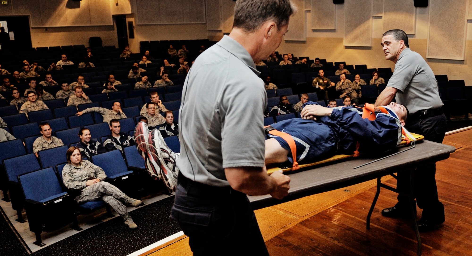 SCOTT AIR FORCE BASE, Ill. -- Vince Easevoli, Stay Alive from Education (S.A.F.E.) executive director, and Ronny Garcia, S.A.F.E. briefer, lay Airman 1st Class Brian Browning, 906th Air Refueling Squadron, on a table to demonstrate some of the things he would experience if he were to be involved in a car crash during a Street Smart presentation Oct. 27. “Street Smart” is a program developed by S.A.F.E. 21 years ago to eliminate trauma related death. (U.S. Air Force photo/ Staff Sgt. Ryan Crane)