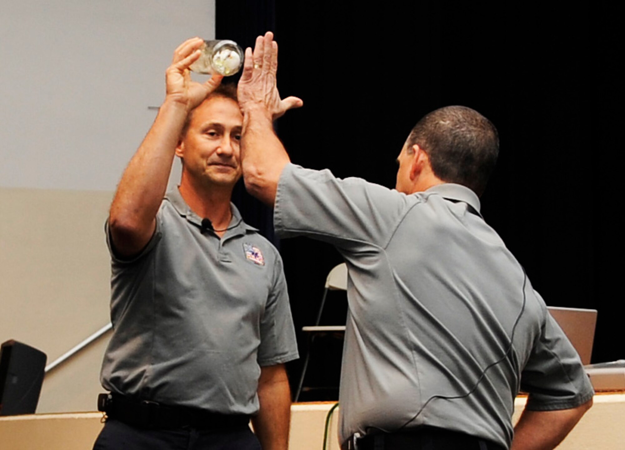 SCOTT AIR FORCE BASE, Ill. -- Vince Easevoli, Stay Alive from Education (S.A.F.E.) executive director, and Ronny Garcia, S.A.F.E. briefer, demonstrate to the audience what happens to your body in a car crash using an egg  and a glass jar during a Street Smart presentation Oct. 27. “Street Smart” is a program developed by S.A.F.E. 21 years ago to eliminate trauma related death. (U.S. Air Force photo/ Staff Sgt. Ryan Crane)
