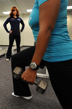 NELLIS AIR FORCE BASE, Nev. -- Gabriela Regino-Colby, a fitness specialist with the Health and Wellness Center, looks on as Capt. Mia Jenkins, 99th Medical Group, does lunges as part of a new fitness program offered by the HAWC Oct. 28. (U.S. Air Force photo / Tech. Sgt. Michael R. Holzworth)
