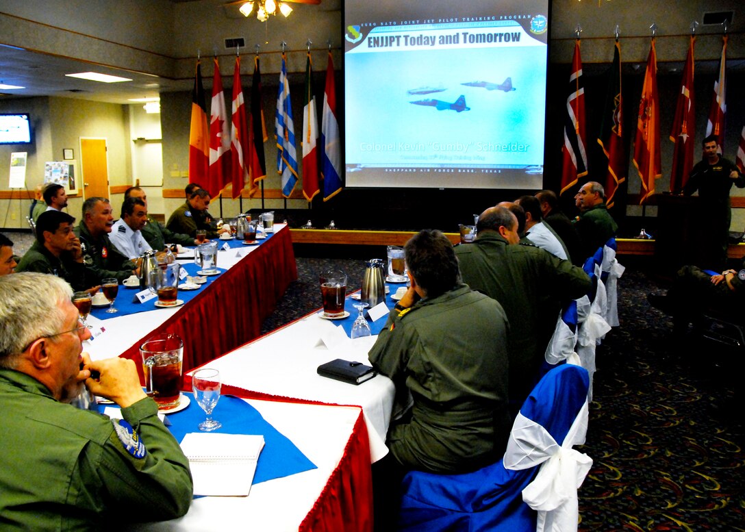 Gen. Roger Brady, bottom left corner, listens as 80th Flying Training Wing Commander Col. Kevin Schneider, top right, provides a mission brief to the U.S. Air Forces Europe commander and Air Chiefs from NATO Oct. 21 at the Sheppard Club. The group made a stop at Sheppard Air Force Base, Texas, to view the training aircraft and flight simulators used to train combat pilots for the NATO alliance. (U.S. Air Force photo/Harry Tonemah)