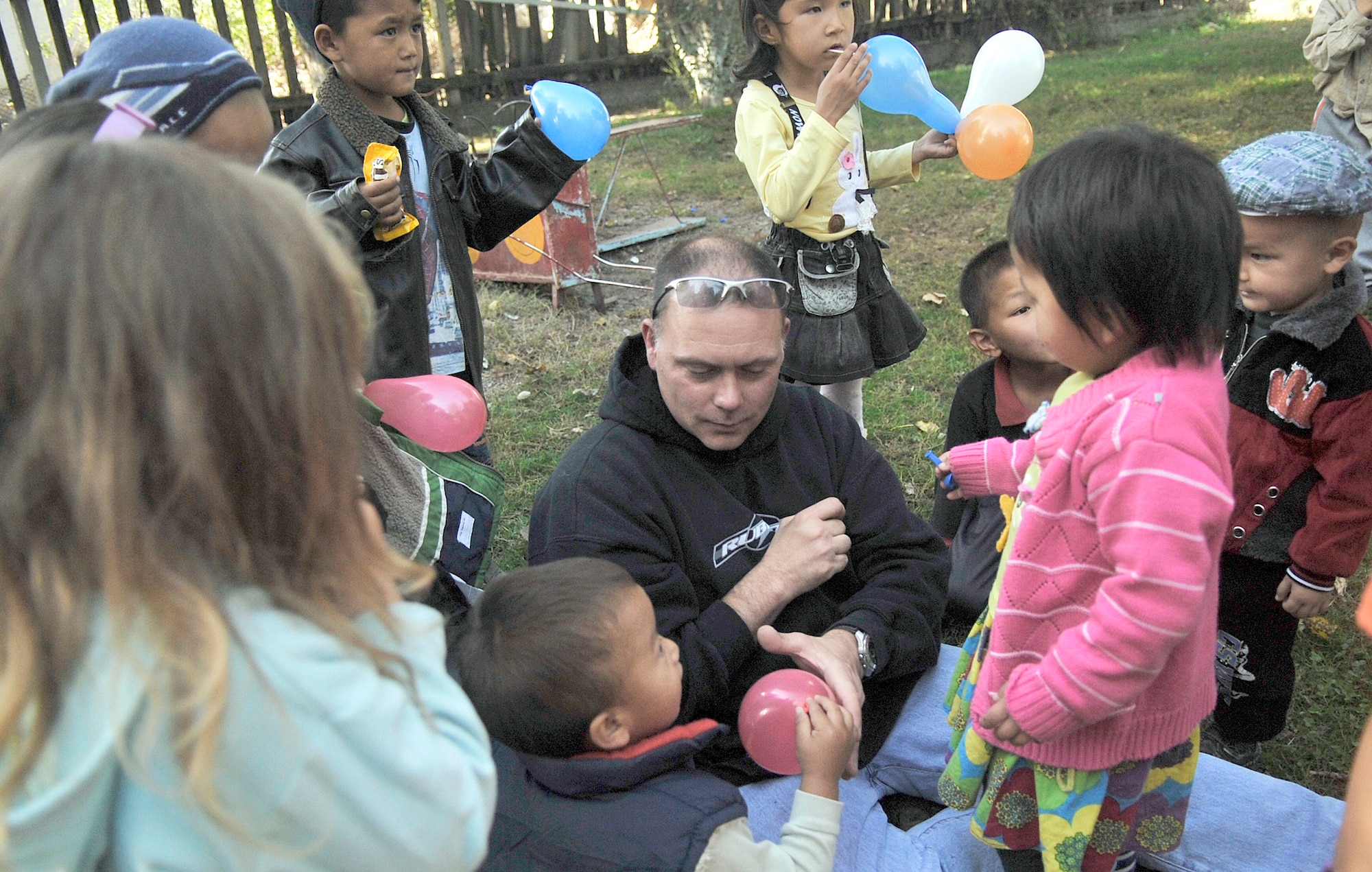 Tech. Sgt. Joe Corder fills balloons for kids Oct. 18, 2010, at the Solnyshko school near Vasilievka, Kyrgyzstan. Several Airmen who are deployed to the Manas Transit Center, Kyrgyzstan, visited the school to deliver cold weather items and spend time with the kids. (U.S. Air Force photo/Staff Sgt. J.G. Buzanowski)