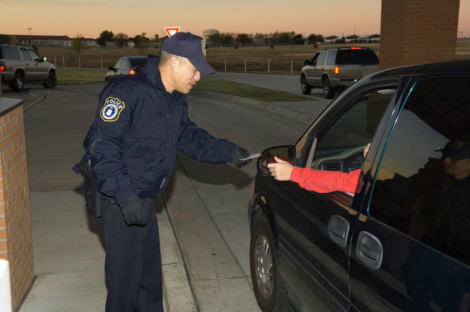 Officer David Tam conducts a security check at the Vance main gate. (U.S. Air Force Photo)