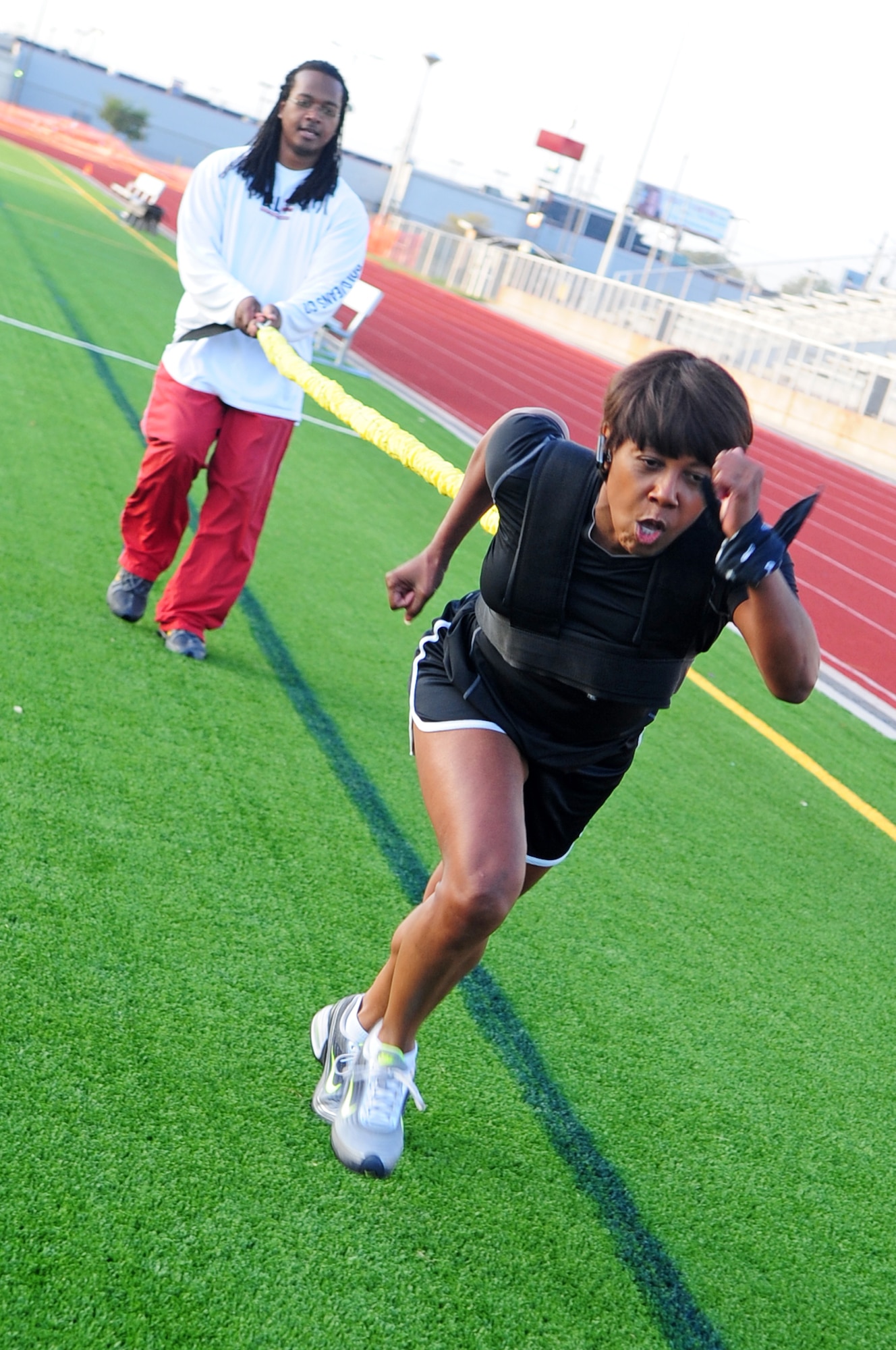 SHREVEPORT, La. -- Tedric Johnson, Health and Wellness Center trainer, provides resistance while Melinda Moody sprints 20 yards as part of the 'rookie runner' program at Captain Shreve Stadium Oct. 27. Mr. Johnson encourages his students to visit the registered dietician at the HAWC to include a balanced diet into their weight loss program. (U.S. Air Force photo/Senior Airman Joanna M. Kresge)