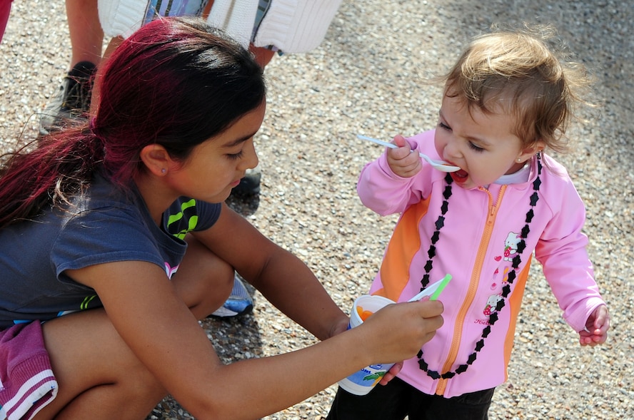 BARKSDALE AIR FORCE BASE, La. -- Abigail Salinas, 9, daughter of Maj. Gina Mills, 8th Air Force, shares a frozen treat with her sister, Sophia Mills-Herring, 19 months, during the fall festival held outside the Stripes Club Oct. 23. The fall festival featured games, sponsor booths, food and a live performance by the band Front Cover featuring Mark Scroggins. (U.S. Air Force photo/Senior Airman Joanna M. Kresge)