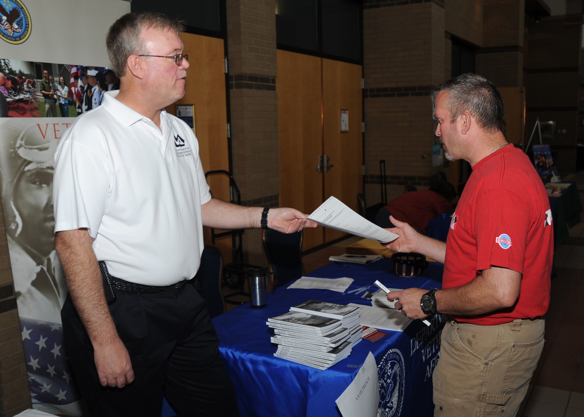 Douglas Chapman, Department of Veterans Affairs service center manager, left, discusses veterans programs with Tech. Sgt. Troy Kaufman, 184th Force Support Squadron fitness and recreation supervisor, during Retiree Appreciation Day, Oct. 23, 2010, McConnell Air Force Base, Kan.  Representatives from the VA, along with the legal office, commissary, Airmen and Family Readiness Center and other organizations had display tables at the event.  (U.S. Air Force photo/Staff Sgt. Dallas Edwards)
