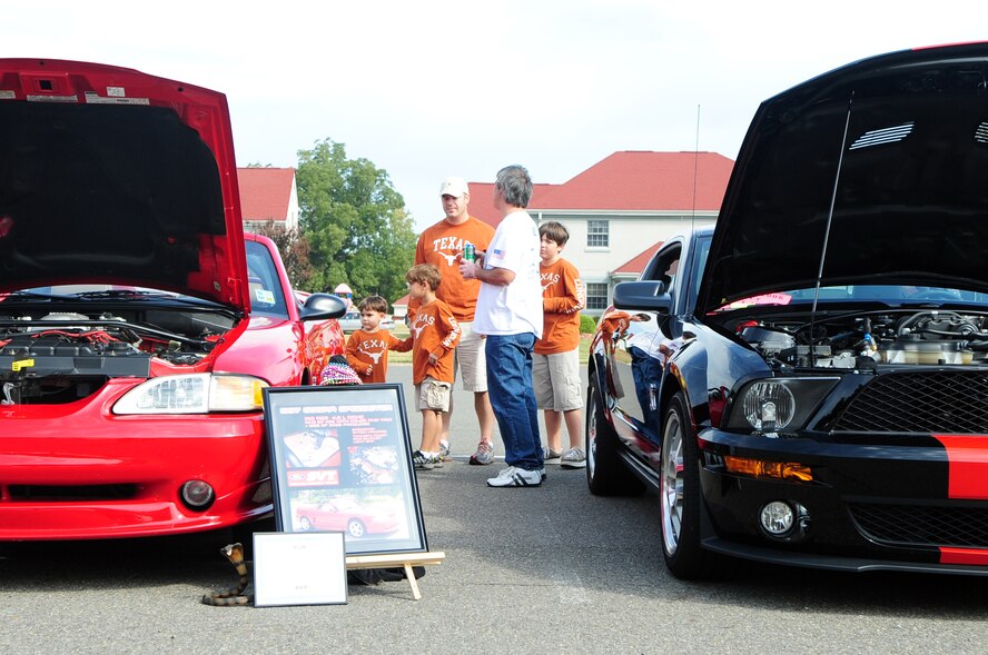 BARKSDALE AIR FORCE BASE, La. -- Kevin Reeves of the Red River Mustang Club talks to Staff Sgt. Marc Tucker, 608th Air Communications Squadron, and his sons Andrew, 10, Michael, 5 and Jonathan, 3, about his 'his and hers' Ford Mustangs during the fall festival held outside the Stripes Club Oct. 23. The fall festival featured games, sponsor booths, food and a live performance by the band Front Cover featuring Mark Scroggins. (U.S. Air Force photo/Senior Airman Joanna M. Kresge)