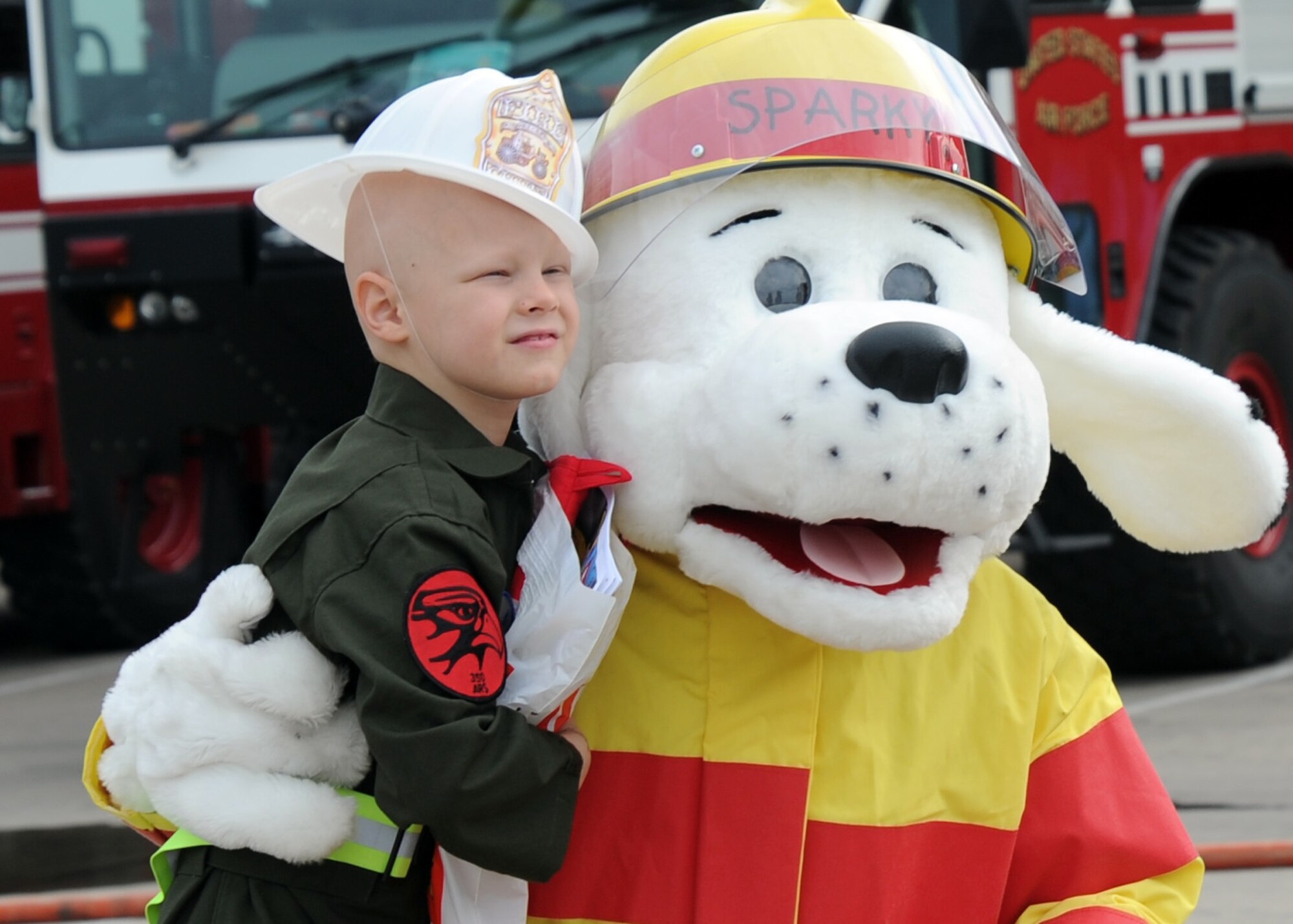 Noah Dossett, 6, Pilot for a Day recipient, poses for photographs with Sparky the Fire Dog at the McConnell Fire Department, Oct. 22, 2010, McConnell Air Force Base, Kan.  Airmen from the 350th Air Refueling Squadron and the base Fire Department spent time with Noah and his family to give them a fun day to remember.  (U.S. Air Force photo/Staff Sgt. Dallas Edwards)