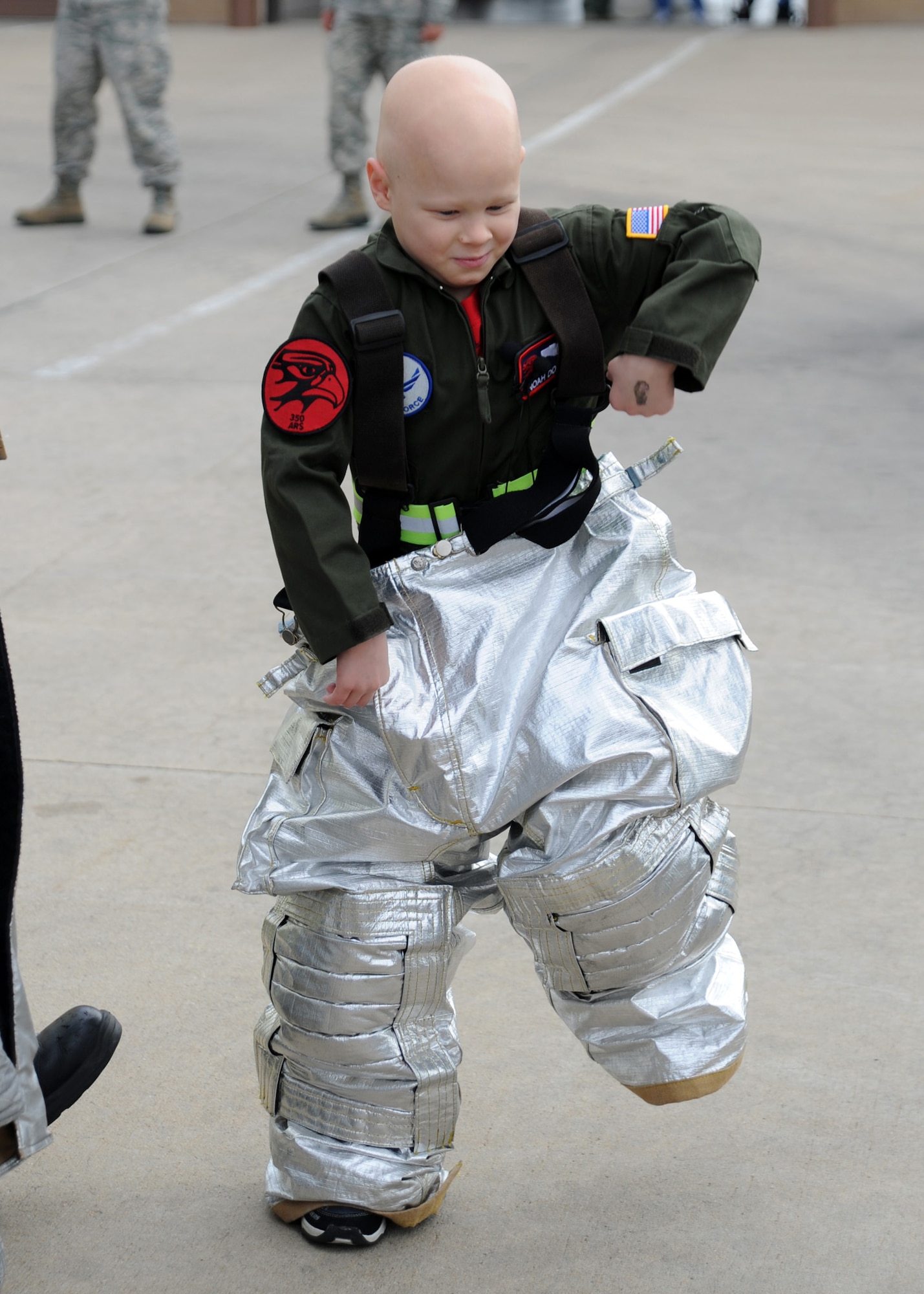 Noah Dossett, 6, Pilot for a Day recipient, walks in a fire suit at the McConnell Fire Department Oct. 22, 2010, during a visit to McConnell Air Force Base, Kan.  Noah, who was diagnosed with leukemia, toured the base with members of the 350th Air Refueling Squadron.  The Pilot for a Day program is a chance for Airmen to give medically-challenged children a memorable VIP tour of McConnell. (U.S. Air Force photo/Staff Sgt. Dallas Edwards)
