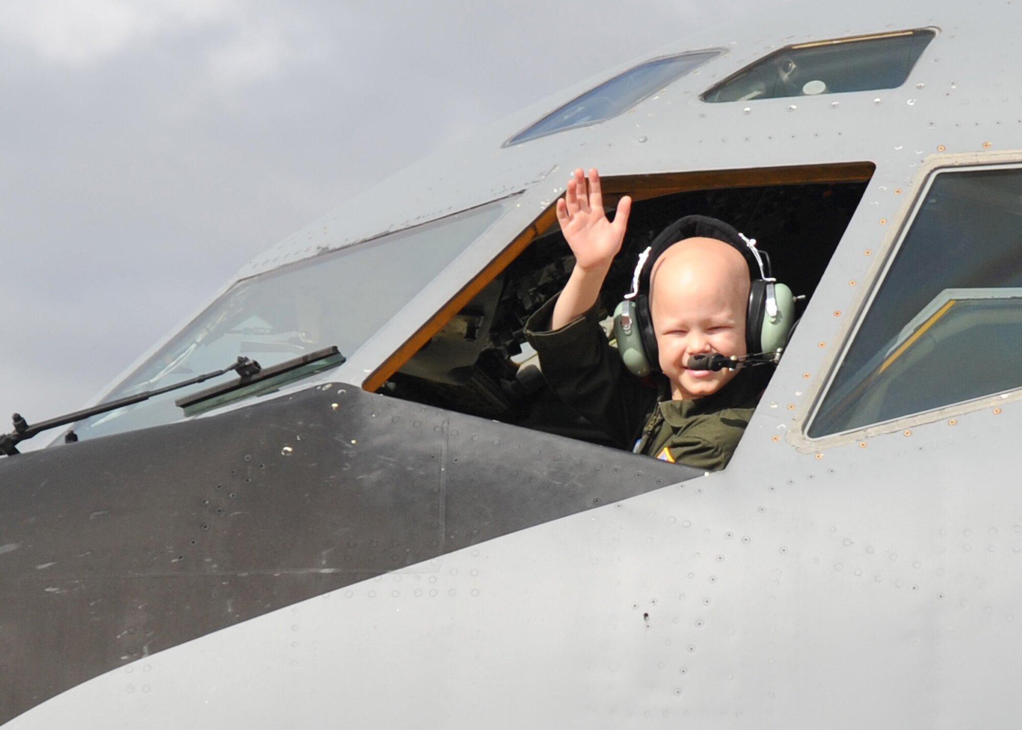 Noah Dossett, 6, Pilot for a Day recipient, waves to people from the flight deck of a KC-135 Stratotanker Oct. 22, 2010, McConnell Air Force Base, Kan.  Noah, who was diagnosed with leukemia, and his family toured the base with members of the 350th Air Refueling Squadron as part of the Pilot for a Day program, an Air Force program that allows medically-challenged youth a chance to visit a base and become part of the Air Force team.  (U.S. Air Force photo/Staff Sgt. Dallas Edwards)