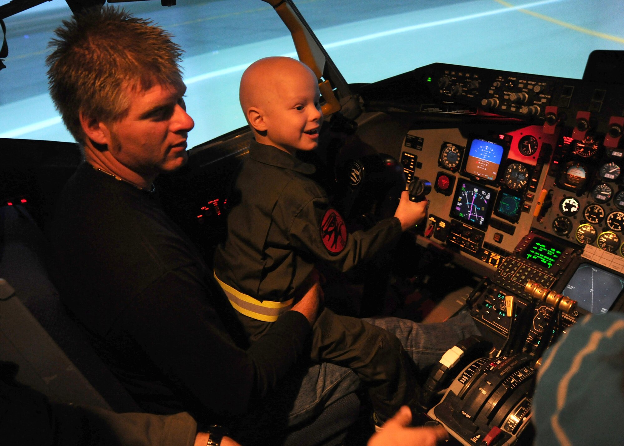 Noah Dossett, 6, Pilot for a Day recipient, operates a flight simulator with Monte Dossett, his father, at a KC-135 Stratotanker simulator training facility Oct. 22, 2010, McConnell Air Force Base, Kan.  Noah, who was diagnosed with leukemia, was invited to the base by members of the 350th Air Refueling Squadron as part of the Pilot for a Day program, an Air Force program that allows medically-challenged youth a chance to tour the base.  Noah was allowed to maneuver the flight simulator to experience first-hand how to operate the aircraft.  (U.S. Air Force photo/Staff Sgt. Dallas Edwards)
