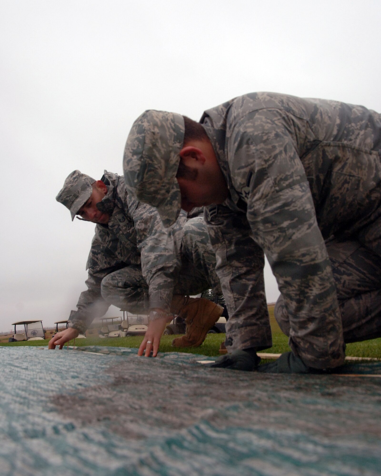Tech. Sgt. Derek E. Worrall (left), 319th Logistics Readiness Squadron, helps another Airman secure a cover over one of the greens at Plainsview Golf Course Oct. 25 on Grand Forks Air Force Base, N.D. (U.S. Air Force photo by Staff Sgt. R. Michael Longoria)