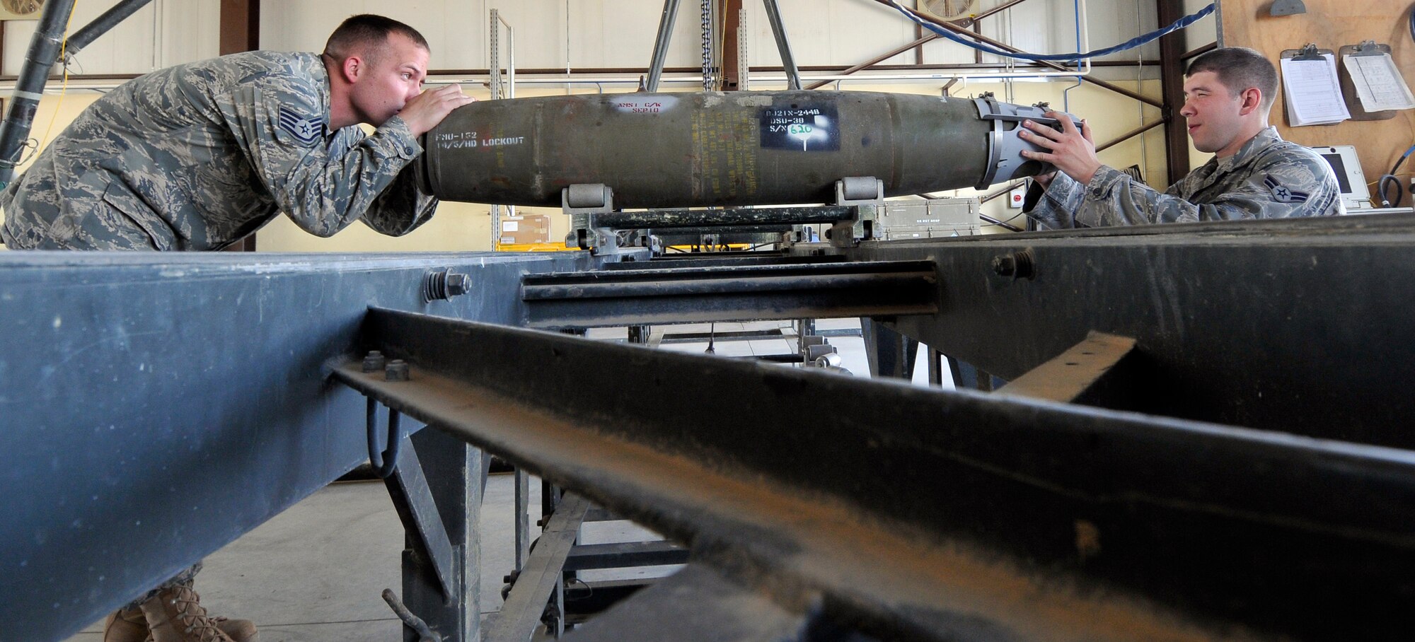 Staff Sgt. Clinton McAlister (left), and Airman 1st Class Michael Razis, 332nd Expeditionary Maintenance Squadron conventional maintenance crew members, align a forward-end adapter strake on a Guided Bomb Unit-54 laser joint direct attack munition Oct. 14, 2010, Joint Base Balad, Iraq. The adapter is used to attach the seeker head to the bomb and aid in flight stability.  Sergeant McAlister is a native of Athens, Texas and Airman Razis is a native of Flint, Texas. Both Airmen are deployed from Misawa Air Base, Japan. (U.S. Air Force photo/Tech. Sgt. Phillip Butterfield)