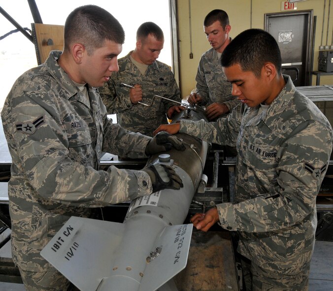 Airmen of the 332nd Expeditionary Maintenance Squadron Munitions Flight tighten screws and bolts on a Guided Bomb Unit-54 laser joint direct attack munition Oct. 14, 2010, Joint Base Balad, Iraq. The GBU-54 is the Air Force's newest 500-pound precision weapon, equipped with a special targeting system that uses a combination of Global Positioning System and laser guidance to accurately engage and destroy moving targets. (U.S. Air Force photo/Tech. Sgt. Phillip Butterfield)