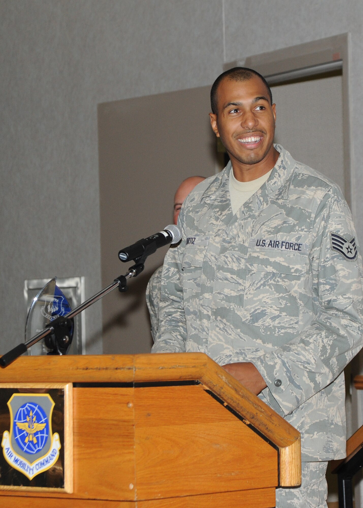 Staff Sgt. Ralph Ortiz, 22nd Force Support Squadron Honor Guard NCOIC, speaks to Team McConnell on behalf of Airman 1st Class Megan Williams, 22nd Logistics Readiness Squadron customer service apprentice, for winning Honor Guard Airman of the Quarter, during the 3rd quarter Quarterly Awards  ceremony Oct. 22, 2010, McConnell Air Force Base, Kan.  The quarterly award winners were recognized for providing sustained superior performance and distinguished themselves through personal and professional achievements. (U.S. Air Force photo/Airman 1st Class Andrea Salazar)