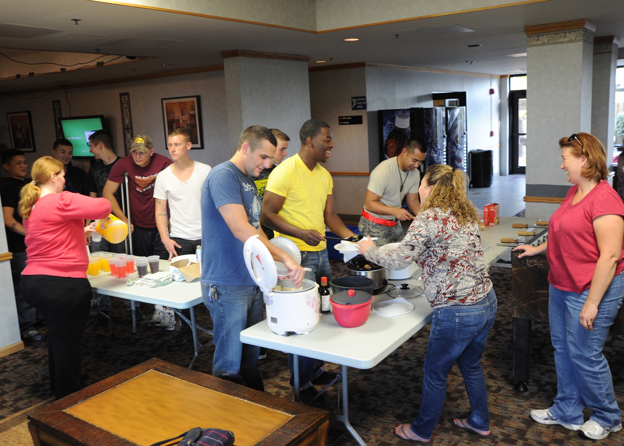 Airmen serve themselves food inside Taylor Hall during a potluck dinner, hosted by members of McConnell’s Enlisted Spouse's Club, Oct. 21, 2010, McConnell Air Force Base, Kan.  Once a month, club members volunteer to make homemade dishes to boost morale for Airmen living in the dorms, giving them options other than the dining facility.  (U.S. Air Force photo/Airman 1st Class Andrea Salazar)