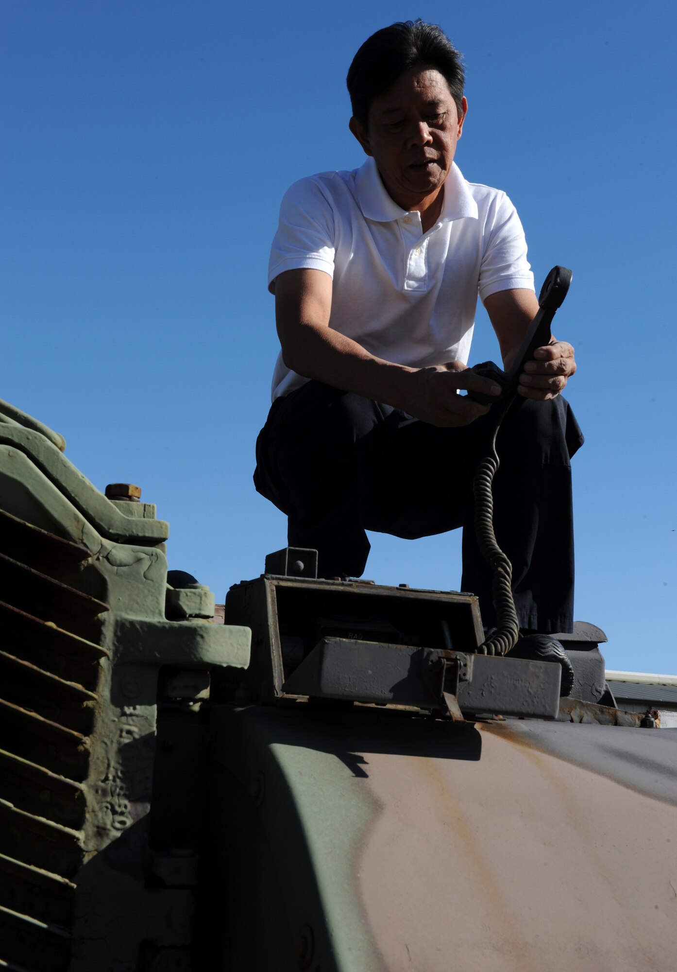 Victor Ambegia, Disposition Services Little Rock property disposal specialist, inspects the phone on an MA81 tank Oct. 27. Mr. Ambegia earned the Defense Logistics Agency Superior Civilian Service Award and the Secretary of Defense Global War on Terrorism Medal for his service and achievements during deployments to Afghanistan and Kyrgyzstan. (U.S. Air Force photo by Airman 1st Class Ellora Stewart)