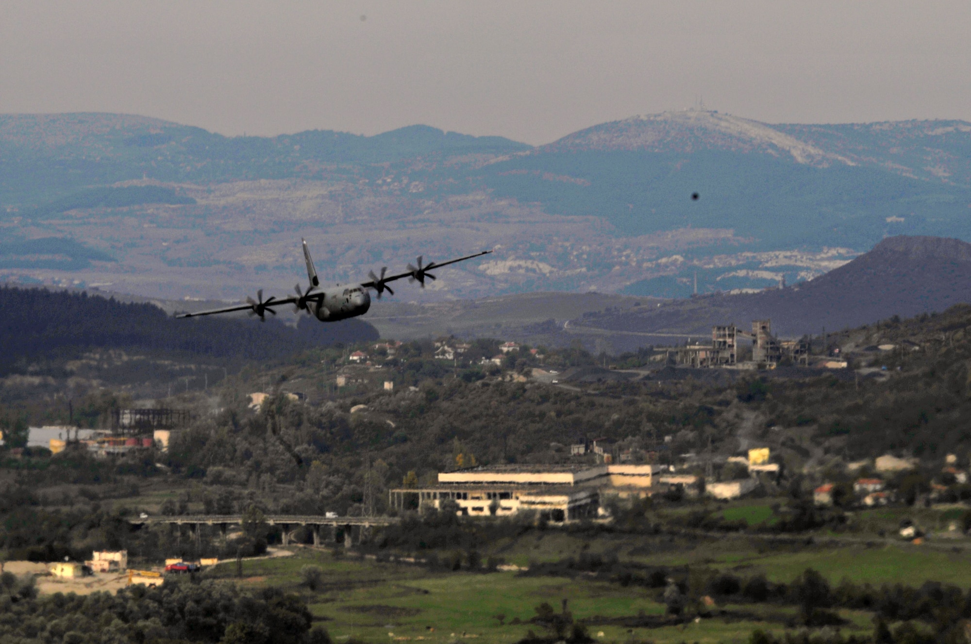 A U.S. Air Force C-130J Super Hercules flies through the mountains surrounding Plovdiv, Bulgaria, during Thracian Fall 2010, Oct. 25. Thracian Fall is a two week on-site training deployment designed to build the partnership between the U.S. and Bulgarian Air Force. (U.S. Air Force photo by Tech. Sgt. Michael Voss)
