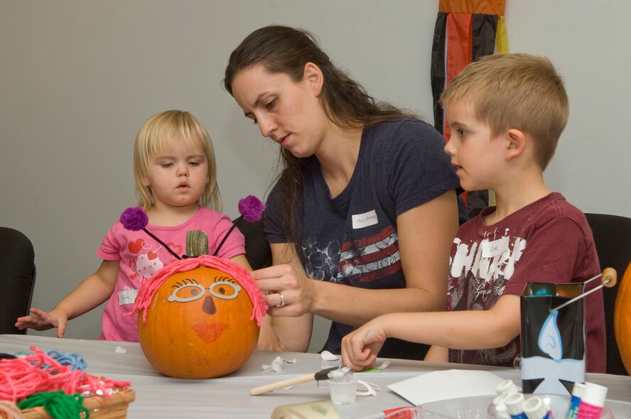 HANSCOM AIR FORCE BASE, Mass. - Deja Stevenson (middle) and her children, Jett and Rylin, put the finishing touches on their pumpkin at the Base Library on October 26. Hanscom families were invited to bring their own pumpkins and decorate them for Halloween. (U.S. Air Force photo by Mark Wyatt)