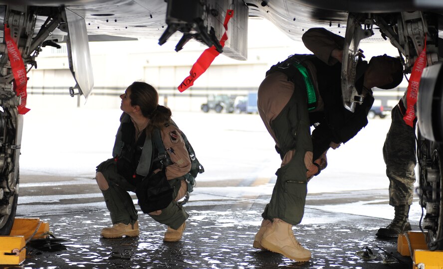 SEYMOUR JOHNSON AIR FORCE BASE, N.C. -- Pilots from the 336th Fighter Squadron perform a pre-flight inspection of their jet prior to take-off here, Oct. 26, 2010. In preparation for the operational readiness inspection over twenty jets were generated and inspected for maintenance operational timliness. (U.S. Air Force photo/Senior Airman Makenzie Lang)(RELEASED)