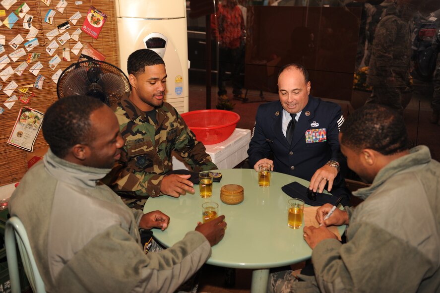 KUNSAN AIR BASE, Republic of Korea -- Chief Master Sgt. James Sanders, 8th Fighter Wing command chief and Staff Sgt. Marcus Williams, Derek Curry and Sergio Griffin, 8th Security Forces Squadron, samples tea at a local business after the New Horizons ribbon cutting ceremony here Oct. 27, 2010. The event marked the lifting of the thirty year old 3-mile restriction surrounding Kunsan AB. (U.S. Air Force photo/Senior Airman Ciara Wymbs)  
