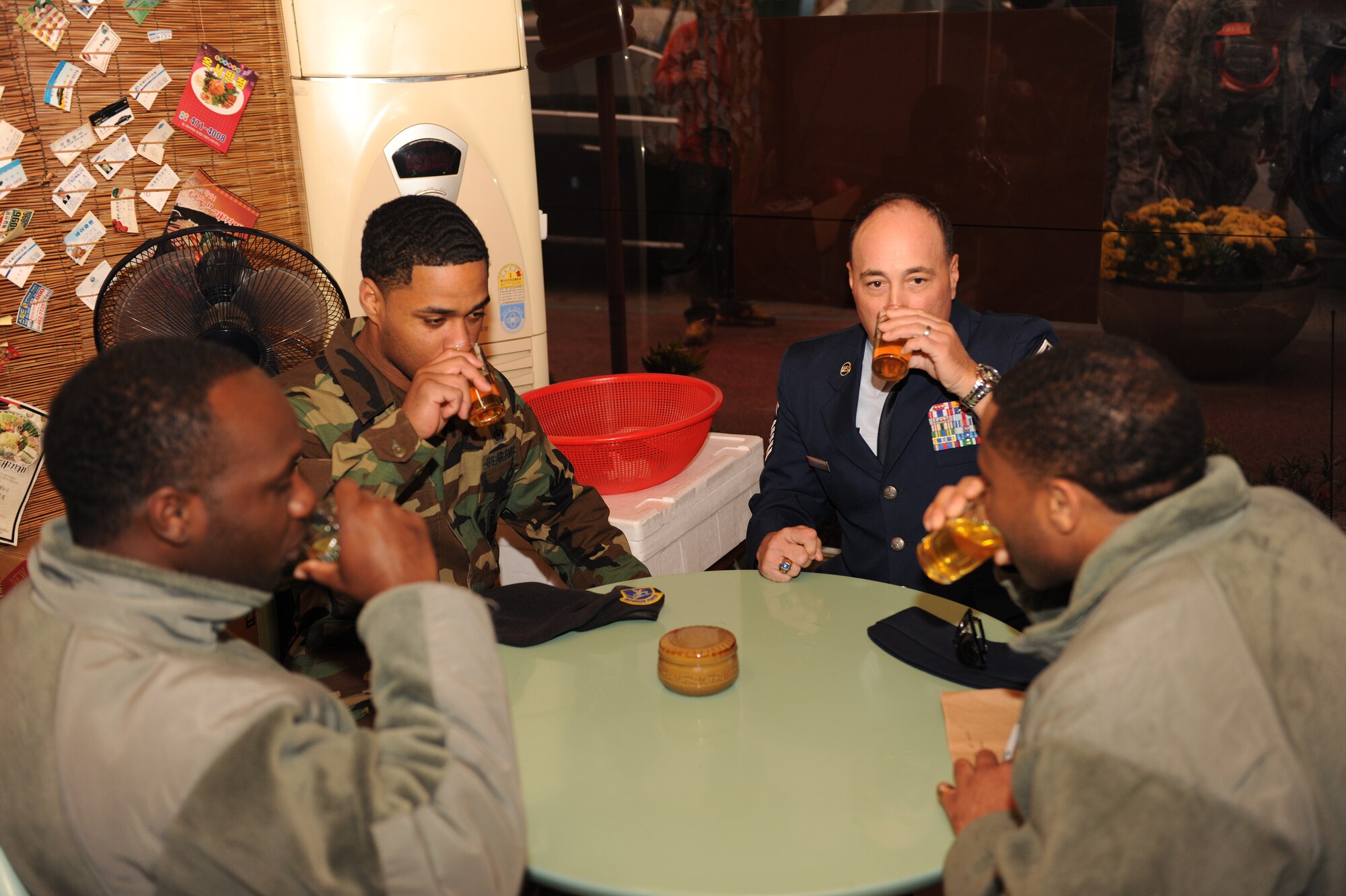 KUNSAN AIR BASE, Republic of Korea -- Chief Master Sgt. James Sanders, 8th Fighter Wing command chief, and Staff Sgts. Marcus Williams, Derek Curry and Sergio Griffin, 8th Security Forces Squadron, sample tea at a local business after the New Horizons ribbon cutting ceremony here Oct. 27, 2010. The event marked the lifting of the fifty-year-old three-mile restriction surrounding Kunsan Air Base. (U.S. Air Force photo/Senior Airman Ciara Wymbs)  