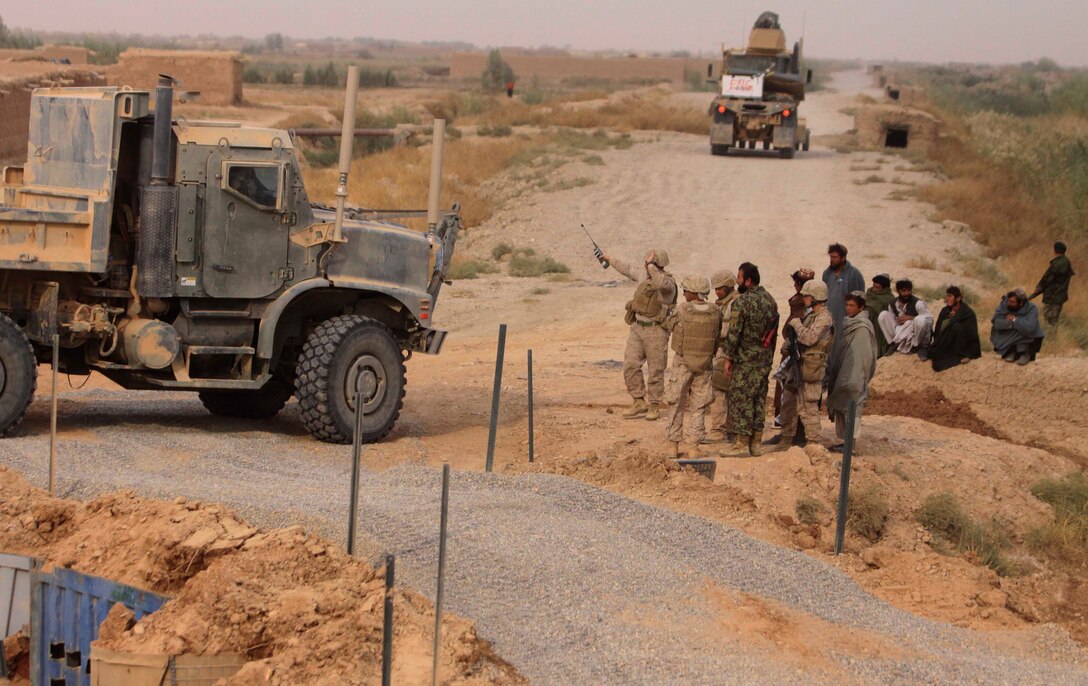 Residents of Trakh Nawa, Afghanistan, watch as the final touches are placed on a bridge construction project, Oct. 28. Approximately 40 Marines with CLB-3’s Engineer Company constructed the bridge in less than two days.
